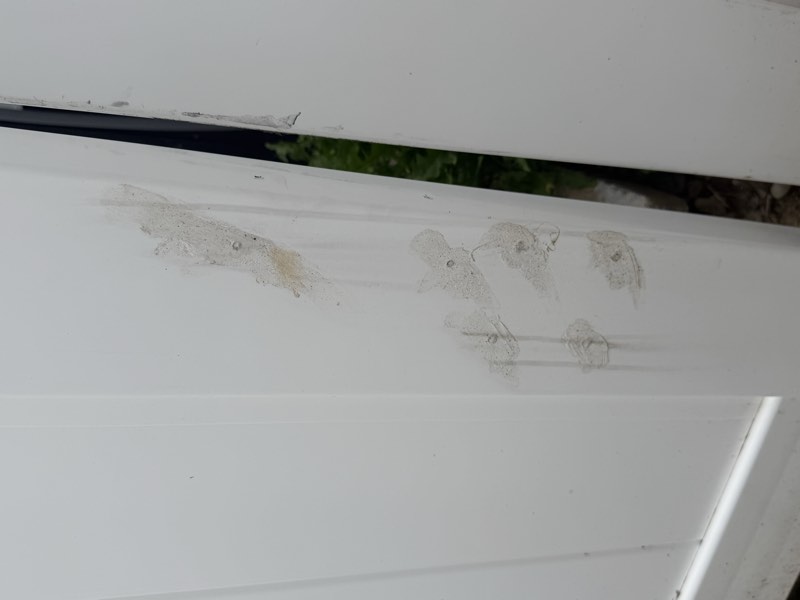 Caulk plugs over abandoned fastener holes with a gap visible at the edge of the post.