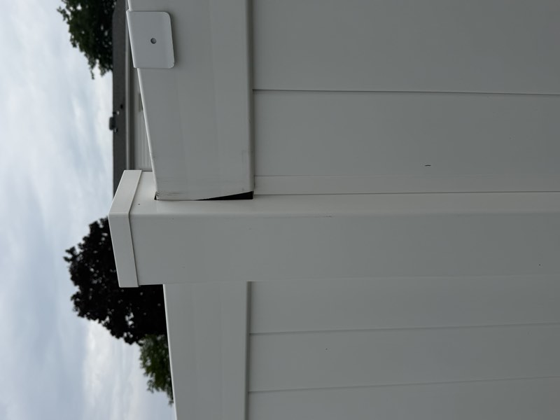 A fence rail separated from the post cap leaving an open cavity at the top of the post.